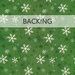 A swatch of green fabric with white and dark green scattered snowflakes.