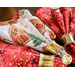 angled view of Red and white christmas napkins in gold napkin rings arranged in a fan on a brown wooden background