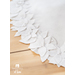 All white tree skirt with a border of layered fabric flowers and foliage.