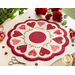 Round white table topper with scalloped edges and red and pink hearts in a circle around it, on a white countertop with red buttons, red thread, red roses, and scissors with a plant in the background