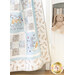 Close up photo of a cream, blue, and grey quilt that features rabbits from the children's book, 