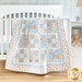 Photo of a cream, blue, and grey quilt that features rabbits from the children's book, 