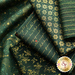 A collection of folded green fabric swatches featuring various patterns, including gold stars, floral designs, and written text.