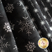 Close up of black fabric with metallic silver winter motifs layered atop one another