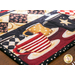 Close up of corner of table runner showing quilting detail on a red and cream striped mug with a black and white polka dotted binding fabric