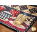 Close up of corner of table runner showing quilting detail on a cream colored mug featuring a star with a black and white polka dotted binding fabric