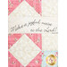 close up of triangle and square blocks in pink and cream floral fabrics with a small panel with the words 