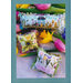 Three decorative cross stitch pillows with spring themes, surrounded by colorful tulips.