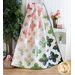 A colorful floral quilt draped on a wooden display, surrounded by plants and decorative items.