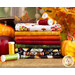 A stack of various fabric rolls in autumn colors, including orange, red, and green, sits alongside spools of thread in yellow and green. The background features pumpkins and colorful leaves, creating a seasonal theme.