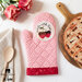 Photo of a pink oven mitt with red trim and a white circle depicting strawberries and the words 