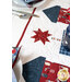 Close up angled photo of the center of the patriotic table runner on a white table with a place setting and matching napkin in the foreground and another in the background