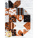 Close up photo of a quilt block featuring a patchwork pumpkin made with orange, cream, and black fabrics.