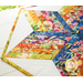 A colorful quilt with a star pattern, featuring vibrant strips of fabric in shades of orange, pink, blue, green, and yellow, against a white background.