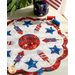 A patriotic red, white, and blue scalloped table topper with stars and fireworks