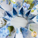 Close up of flower-shaped table topper showing folded floral fabrics in white, blue, and green