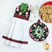 Hanging towel and hot pad for December, featuring Santas, snowflakes, and evergreen trees with buffalo check accents on a white countertop with a plate of chocolate chip cookies, a glass of milk, and peppermints