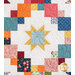 A colorful quilt featuring a central star design surrounded by various patchwork squares in shades of blue, orange, yellow, pink, and floral patterns against a cream background.