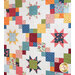 A colorful quilt featuring a patchwork design with various star shapes, squares, and floral patterns in shades of red, blue, orange, green, and yellow against a light background.