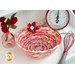 Photo of a bowl made from coiled red and cream colored fabrics with a red fabric flower, from the Little Sweetheart collection, sitting on a white countertop with a red whisk, scale, and pink bottle with red roses in it.