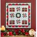 Photo of a finished Happy Holidays mini quilt hanging on a red paneled wall with Christmas decor of evergreen boughs, candles, and wrapped gifts.