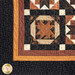 Close up of a single quilt block featuring a traditional pattern made with brown, orange, and black fabrics