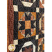 Close up of a single quilt block featuring a traditional pattern made with brown, orange, and black fabrics