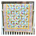 Photograph of multicolor geometric quilt hung over a banister