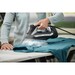 woman ironing a green shirt with steam