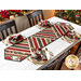 Photo of finished table runner on a long wooden table with four place settings and chairs in a room with garland in the background and a decorated Christmas tree at one side