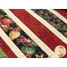 Photo of finished table runner on a long wooden table with four place settings and chairs in a room with garland in the background and a decorated Christmas tree at one side