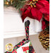 Close up photo of the top of the stocking hanging from a loop on a white mantle with a poinsettia and pinecone garland in the background