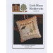 Front of pattern showing the completed small cross stitch ornament staged beside a pinecone