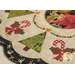 A decorated table mat featuring green Christmas trees, red bows, and candy cane motifs, with a circular design and a floral border.