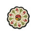 A round table mat featuring a scalloped edge, decorated with Christmas trees, poinsettias, and candy canes, with a central image of a poinsettia and an orange.