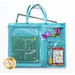 A turquoise crafting tote with a cutting mat, rotary cutter, scissors, thread, and a project pattern.