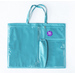 The front of the teal tote, showing three vinyl pockets and one long cloth pocket