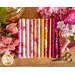 pink, fuchsia, and gold floral fabrics on a wood table surrounded by flowers and thread