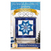 Front cover of the pattern booklet featuring a photo of the completed quilt block featuring a pinwheel shaped snowflake made with different shades of blue fabric with a white background and dark blue border hanging on a tabletop craft holder atop a wooden counter with winter decor and including designer and pattern name info.