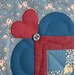 A super close up on a laser-cut heart and fabric-covered button, demonstrating appliqué, stitching, and embellishment details.