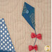 A close up on a blue kite with fabric bows and a fabric-covered button, demonstrating fabric, stitching, and embellishment details.