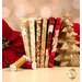 A stack of the fabrics included in the Holiday Flourish Festive Finery FQ set, with a tree and pointsettas and thread.