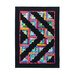 A colorful quilt featuring a zigzag pattern made up of vibrant fabric pieces in various colors, set against a black background. The design includes multiple diagonal lines and geometric shapes, creating a dynamic visual effect.