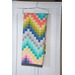 Colorful zig zag patchwork quilt draped over a hanger