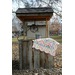 A rustic wooden well draped with a colorful quilt with a scalloped border.