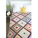 A colorful quilt with around the world blocks covering a bed.