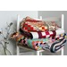 A stack of colorful quilts neatly folded on a white chair.