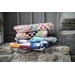 A stack of colorful quilts resting on a stone ledge.