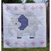 A quilt featuring a pixelated gray elephant with a dark blue patch against a white background and pink crosses.