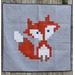 Quilt featuring a pixelated red fox design on a gray background.